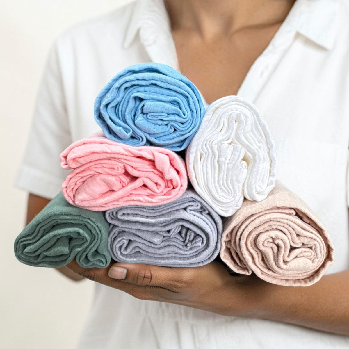 Double cotton swaddle wraps held in hands